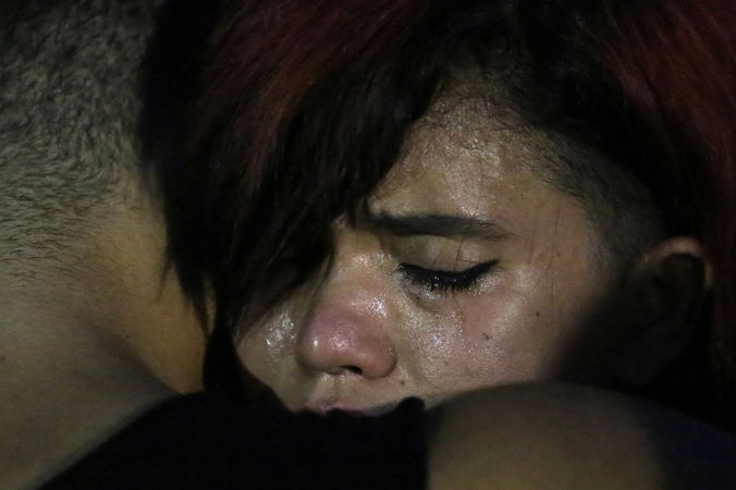 A woman cries during a vigil in a park following a mass shooting at the Pulse gay nightclub in Orlando Florida
